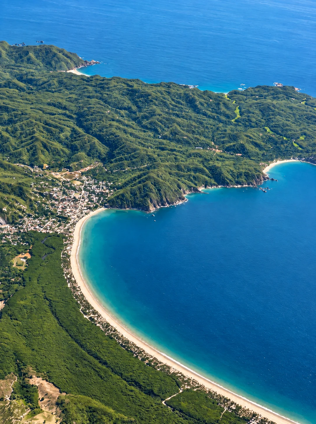 Sunny aerial view of La Manzanilla, its sweeping bay and the Costalegre coastline
