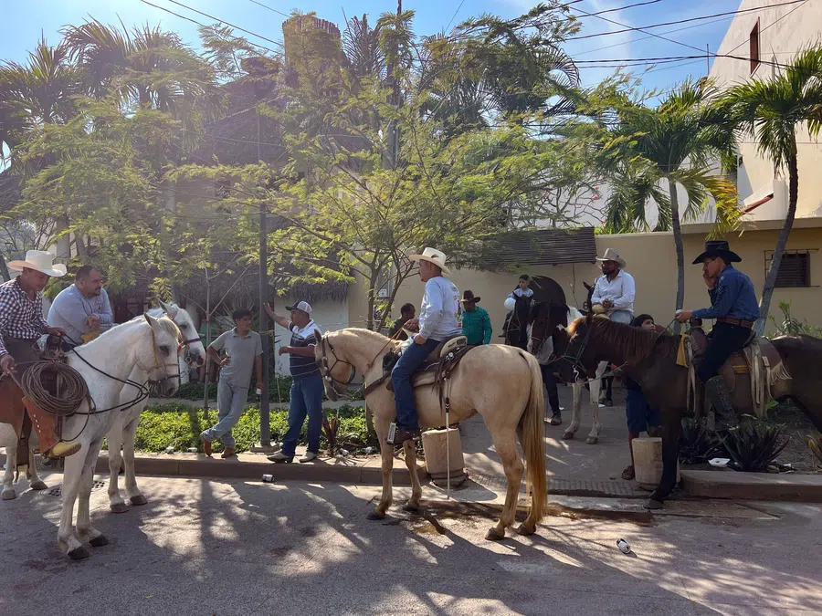 Local riders gather on horseback along a village street, reflecting the region's enduring ranching culture.