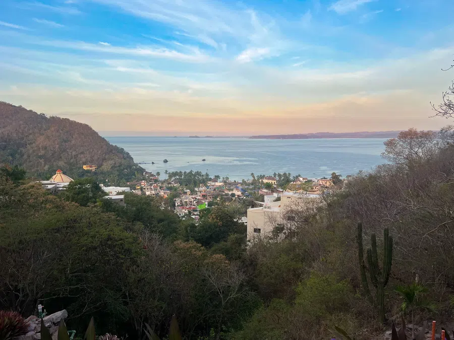 View across La Manzanilla and the bay as the evening light softens over the coast.