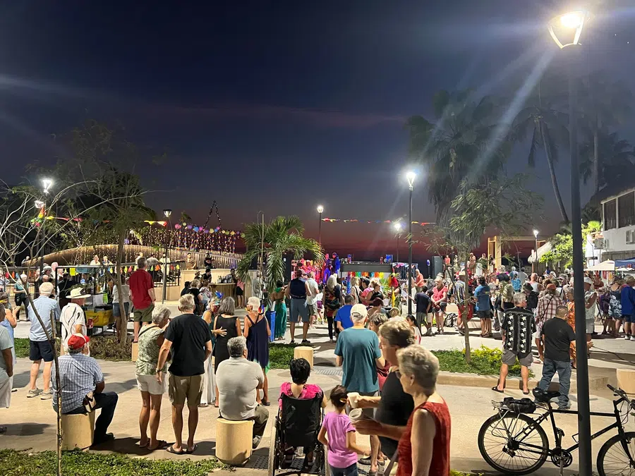 Crowds gather outdoors for an evening event in the heart of La Manzanilla.