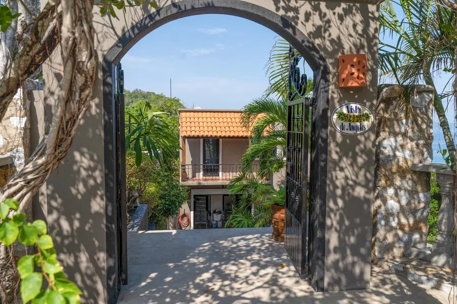Arched garden entrance opens onto a shaded path between the residences.