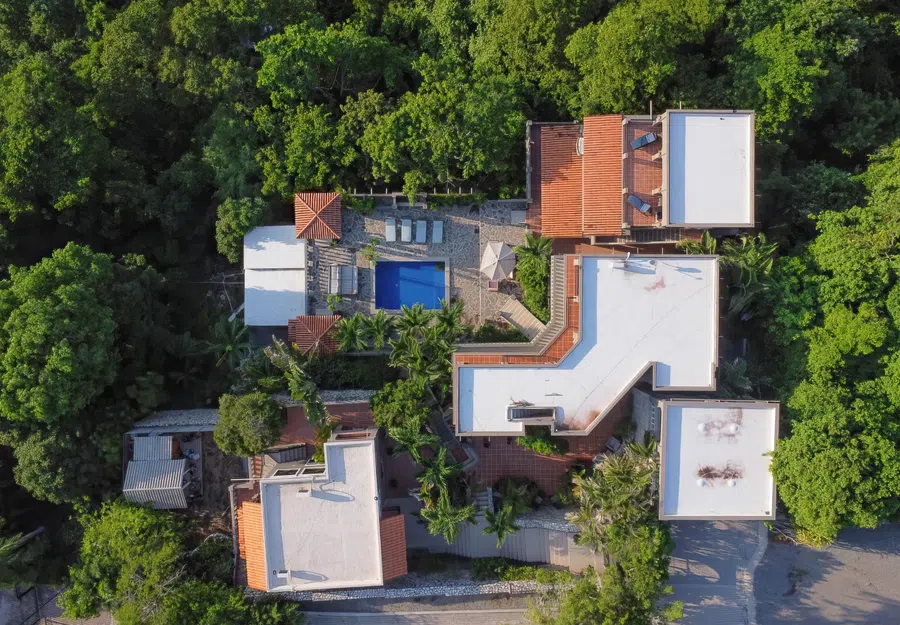 Top-down drone view showing the full Casa Vista de Ángeles compound nestled into dense tropical greenery, including the pool and multiple residences.