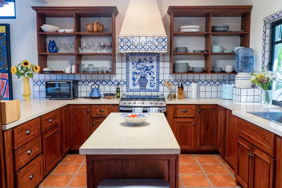 Large kitchen with wood cabinetry, center island and distinctive Mexican tilework.