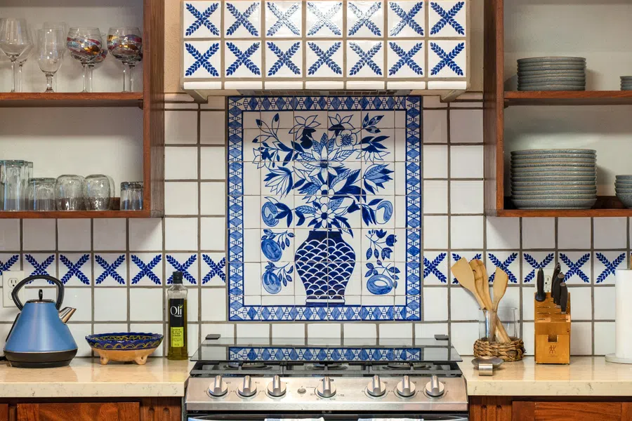 Decorative blue-and-white tile creates a distinctive focal point behind the range.