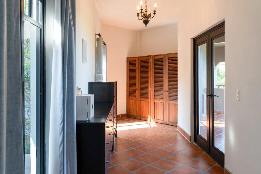 Light-filled 3rd floor hallway with terracotta floors connects the main residence's private spaces.