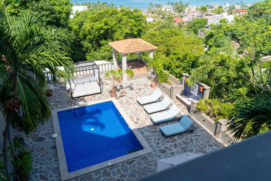 Elevated view from the master bedroom balcony over the pool deck toward La Manzanilla and the Pacific.