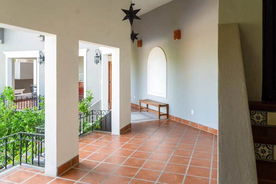 Main-residence first floor open-air tiled landing and balcony overlooking the pool area