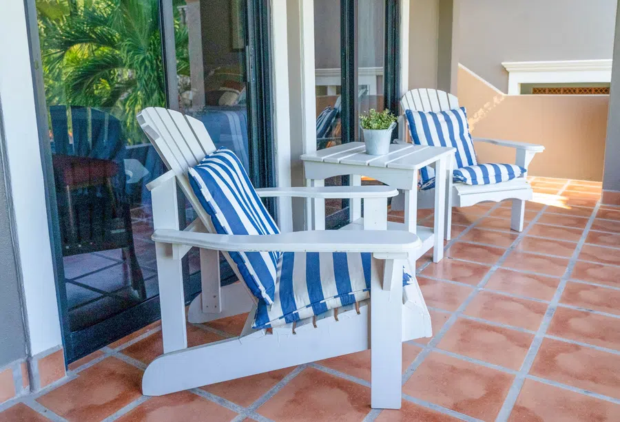 Covered balcony attached to master bedroom with Adirondack chairs provides a relaxed place to enjoy the tropical setting.