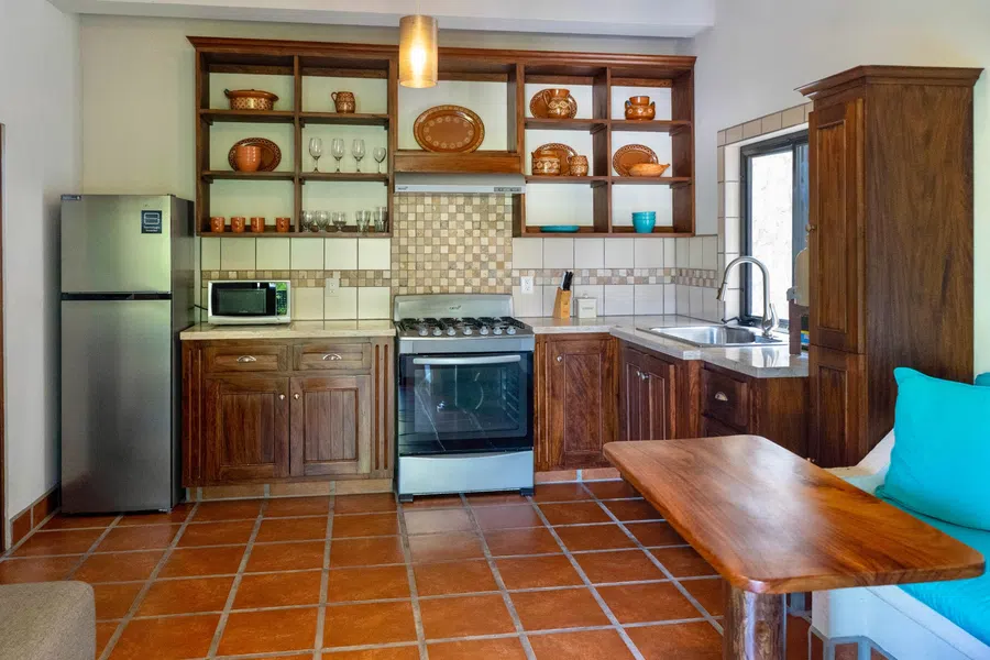Full kitchen with wood cabinetry, range and refrigerator gives the casita complete independence.