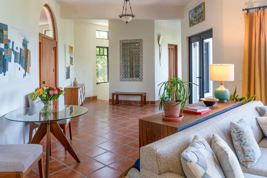 Open living and dining area with handcrafted furnishings, terracotta floors and abundant natural light.